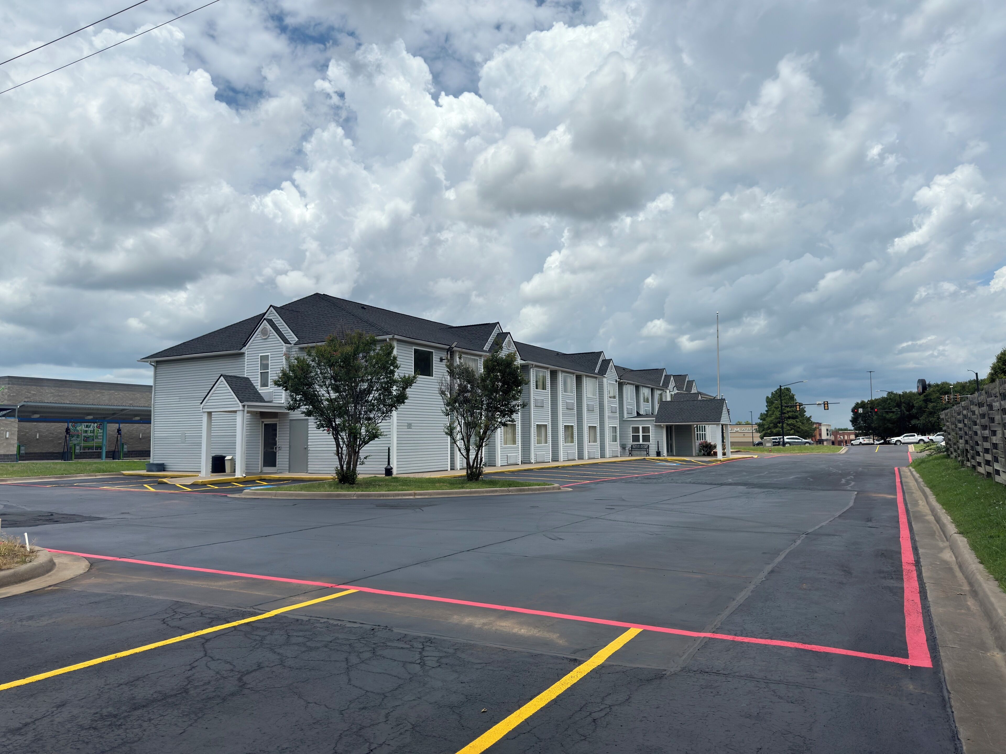 A row of white buildings with a parking lot in front.