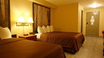 Une chambre d’hôtel avec deux lits, une table de chevet, une lampe et une porte à clé.