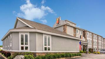 A hotel with a modern design, featuring a prominent American flag and a logo on the building.
