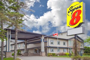 Um hotel com uma grande placa da Super 8, várias janelas e uma bandeira.