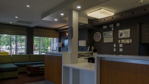 A modern reception area with a counter, seating, and a view of the outdoors.