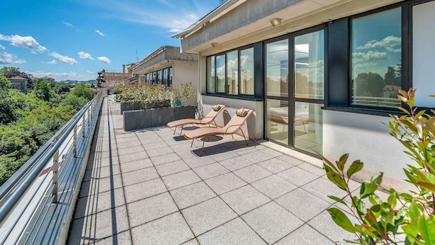 Terraço no telhado com assentos e vista para a cidade.