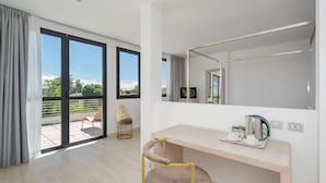 Quarto moderno com uma janela grande, uma mesa com chaleira e uma cadeira.