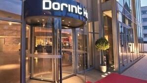 A modern building with a glass facade and a revolving door entrance. - Dorint Hotel am Heumarkt Köln (Cologne)