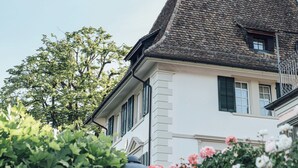 A building with a steeply pitched roof and a weather vane on top. - Seehotel Sonne (Kuesnacht)