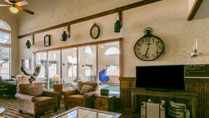 A lobby with a large wall clock, comfortable seating, a glass coffee table, and a television. - Comfort Inn Warrensburg Station (Warrensburg)