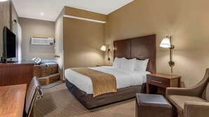A hotel room with a large bed, a desk, a chair, a TV, and a bathroom with a shower and toilet. - Comfort Inn Warrensburg Station (Warrensburg)