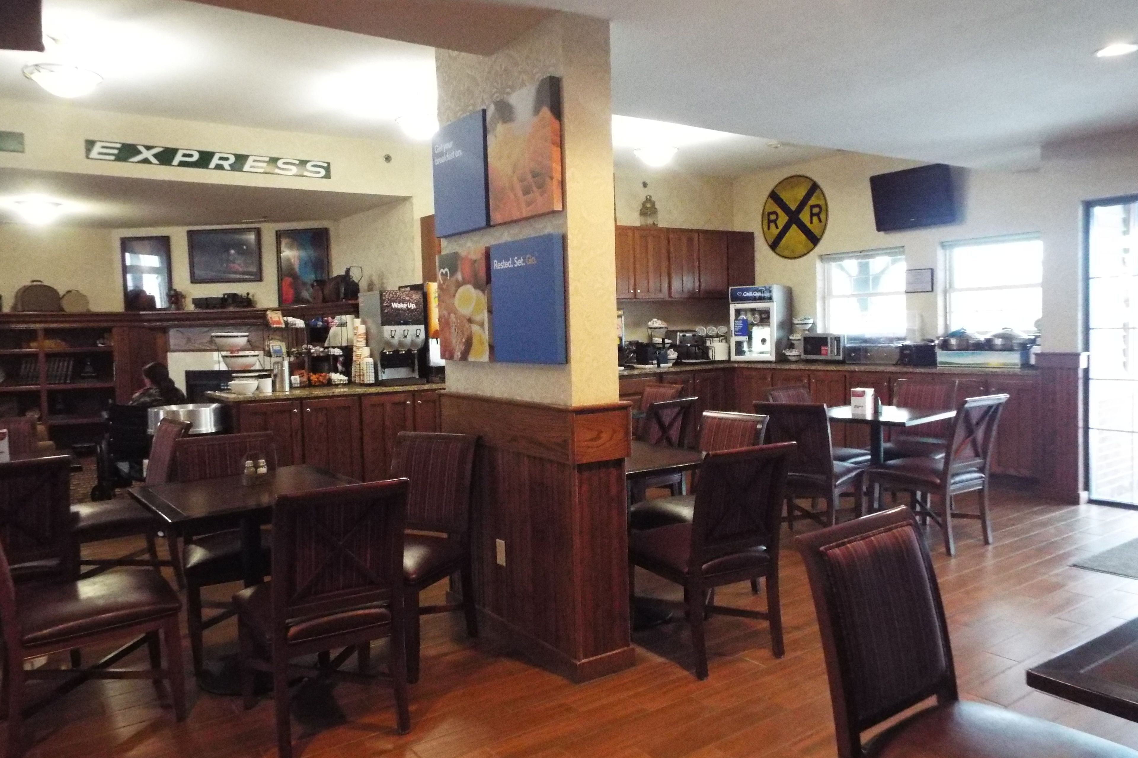 Un restaurante con mobiliario de madera, una zona de cocina y un letrero que dice 'EXPRESS'.