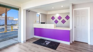 A reception area with a purple counter, a security camera, and a door to the right.