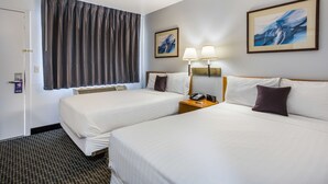 A hotel room with two beds, a nightstand with a telephone, two wall-mounted lamps, and a large window with curtains.
