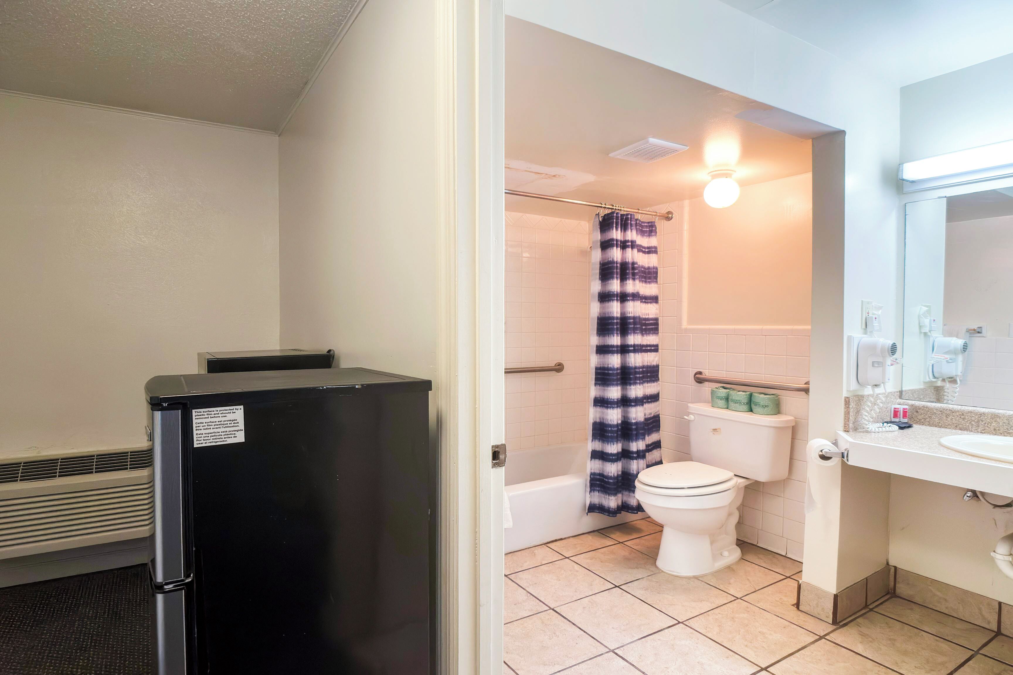 A bathroom with a toilet, shower, and sink.
