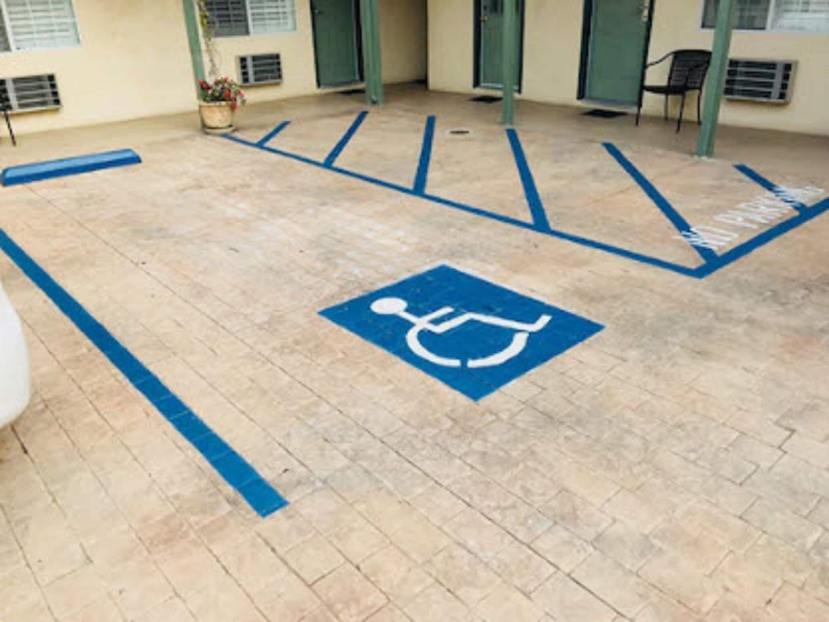 A parking area with a wheelchair accessibility symbol, indicating a designated parking space for disabled individuals.