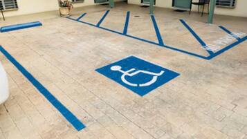 A parking area with a wheelchair accessibility symbol, indicating a designated parking space for disabled individuals.