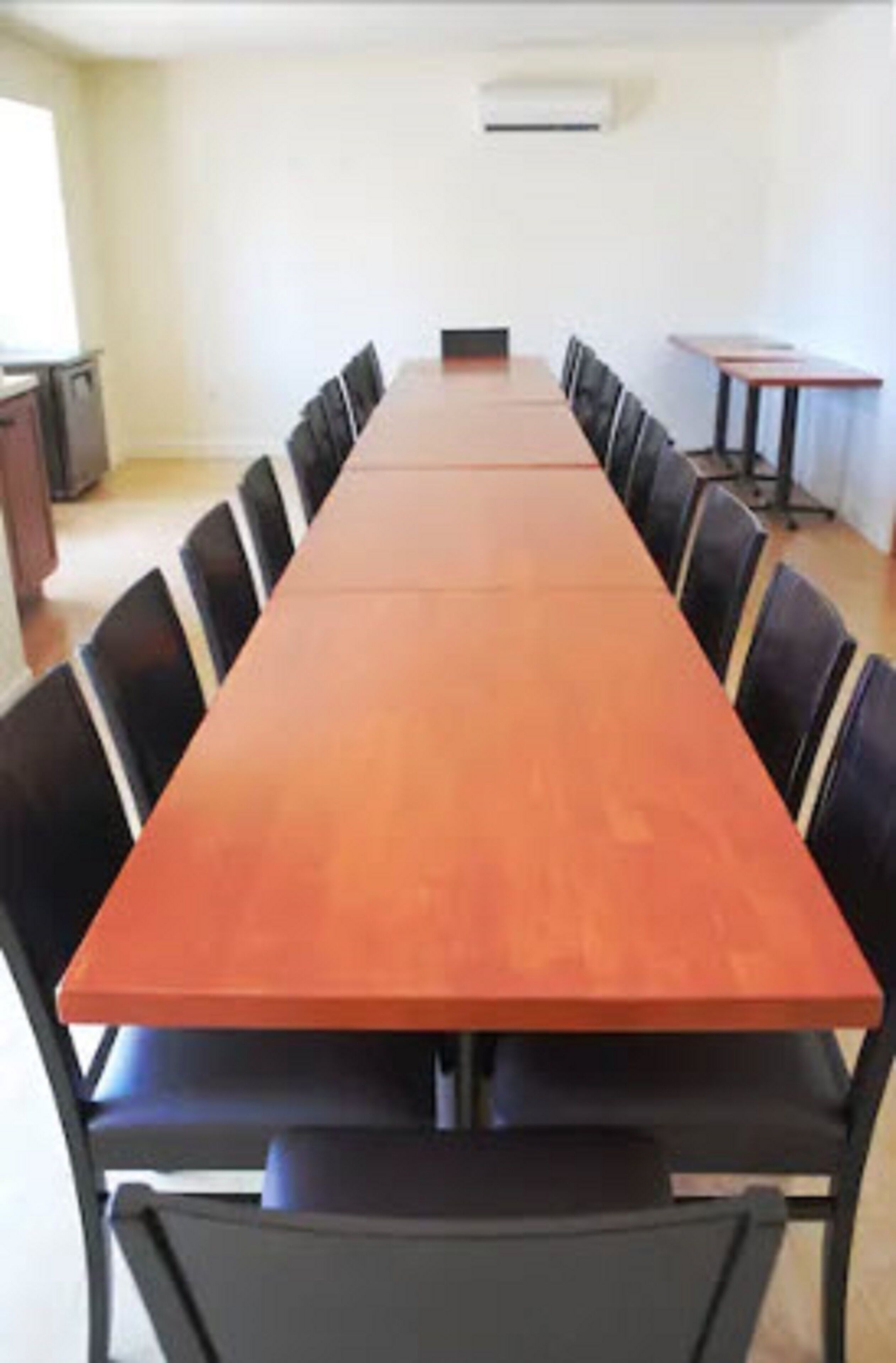 A conference room with a long table and black chairs.