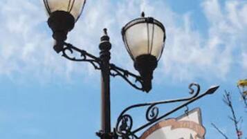 A street sign for Ventura Oak Street with two street lamps.