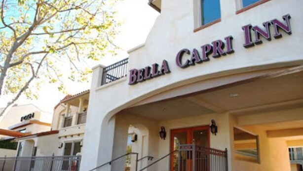 The exterior of Bella Capri Inn, featuring a prominent entrance with a balcony and a staircase leading to the main entrance. - Bella Capri Inn (Camarillo)
