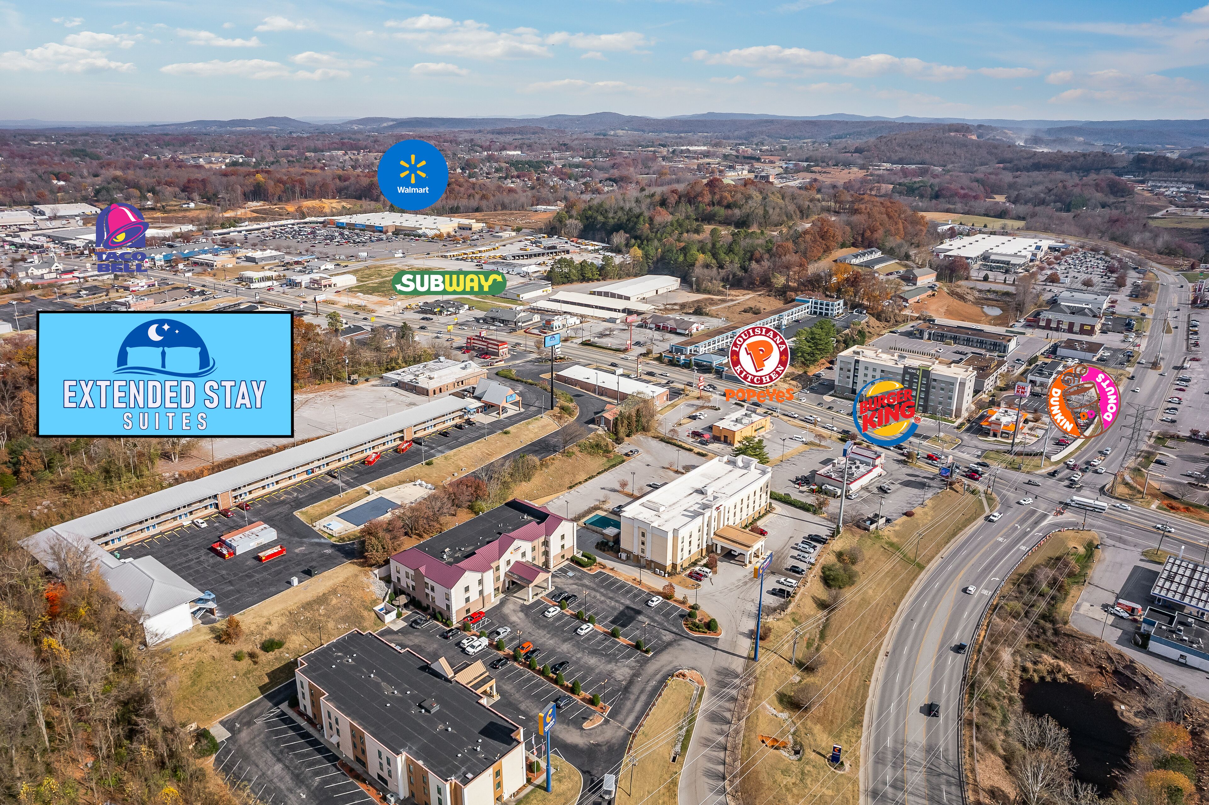 Vue aérienne d’une zone commerciale comprenant un magasin Walmart, un restaurant Subway, un hôtel Extended Stay Suites et un restaurant King King.
