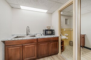 Una cocina con encimera de granito, pileta de acero inoxidable y muebles de madera.