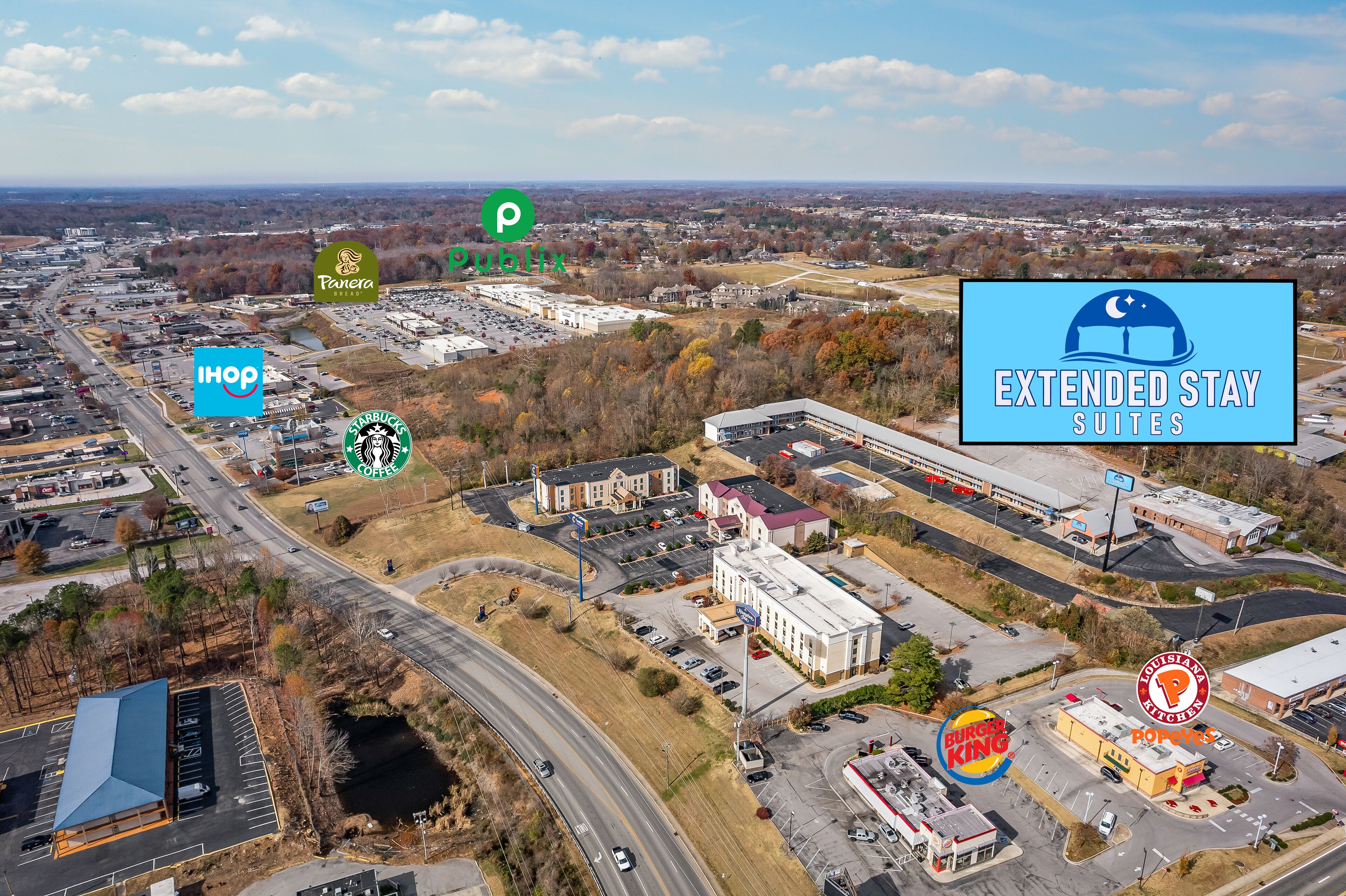 An aerial view of a commercial area with various businesses including IHOP, Panera, Starbucks, Extended Stay Suites, Burger King, and Popeyes.