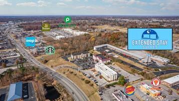 An aerial view of a commercial area with various businesses including IHOP, Panera, Starbucks, Extended Stay Suites, Burger King, and Popeyes.