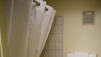 A bathroom with a bathtub, toilet, and shower curtain.