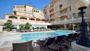 Una piscina al aire libre de temporada, sombrillas, tumbonas