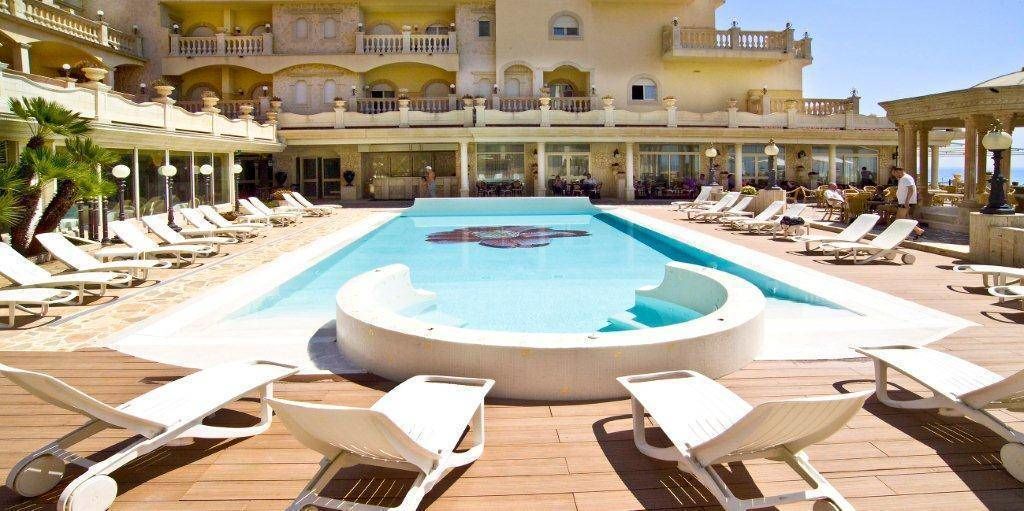 A pool area with sun loungers and a central water feature.