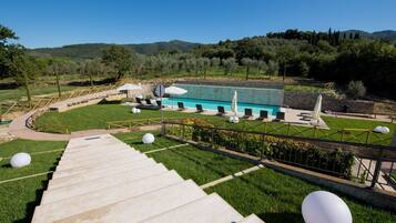 Area piscina con vista diretta sulla vasca, sdraio e una scalinata che scende.