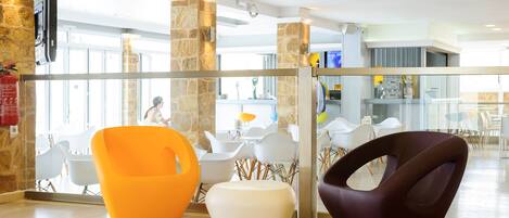 A modern lobby with a stone wall, a glass partition, and contemporary seating.