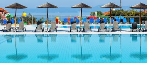 Piscine extérieure, parasols de plage, chaises longues