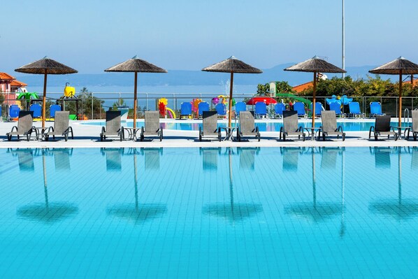 Piscine extérieure, parasols de plage, chaises longues