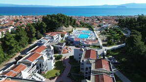 A coastal resort with a swimming pool, terraced buildings, and a view of the sea. - Atrium Hotel (Kassandra)