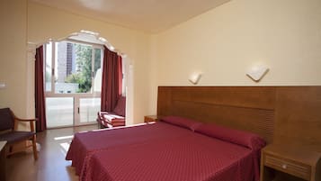 Une chambre d’hôtel avec un grand lit, un bureau, une chaise et une vue sur l’extérieur.