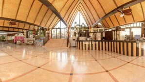A spacious lobby with a high ceiling, a central staircase, and a reception desk. - Magic Tropical Splash (Finestrat)