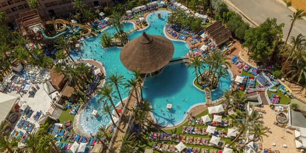 Una piscina al aire libre, sombrillas, tumbonas