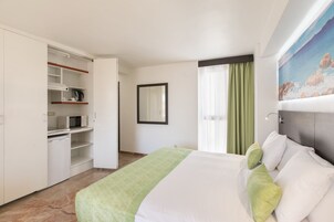 Minibar, caja fuerte, tabla de planchar con plancha y ropa de cama