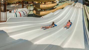 A water park with multiple water slides and a cityscape in the background.