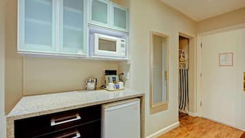 A compact kitchen with a microwave, coffee maker, and a small refrigerator.