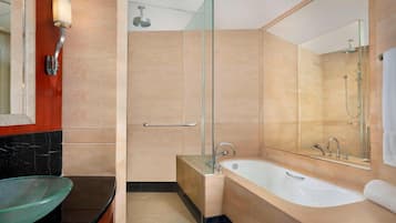 A modern bathroom with a glass-enclosed shower, a freestanding bathtub, and a glass bowl sink.