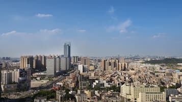 Paisatge urbà amb edificis alts, una combinació d'edificis residencials i comercials, i un cel blau clar.