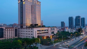 Un hotel moderno de gran altura con una entrada destacada y varios pisos.