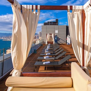 A sun deck with lounge chairs and a view of the city and sea. - Magic Aqua Rock Gardens (Benidorm)