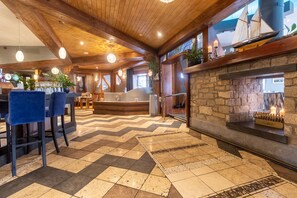 A spacious lobby with a checkered floor, wooden ceiling beams, and a stone fireplace. - Carrigaline Court Hotel and Leisure Centre (Carrigaline)