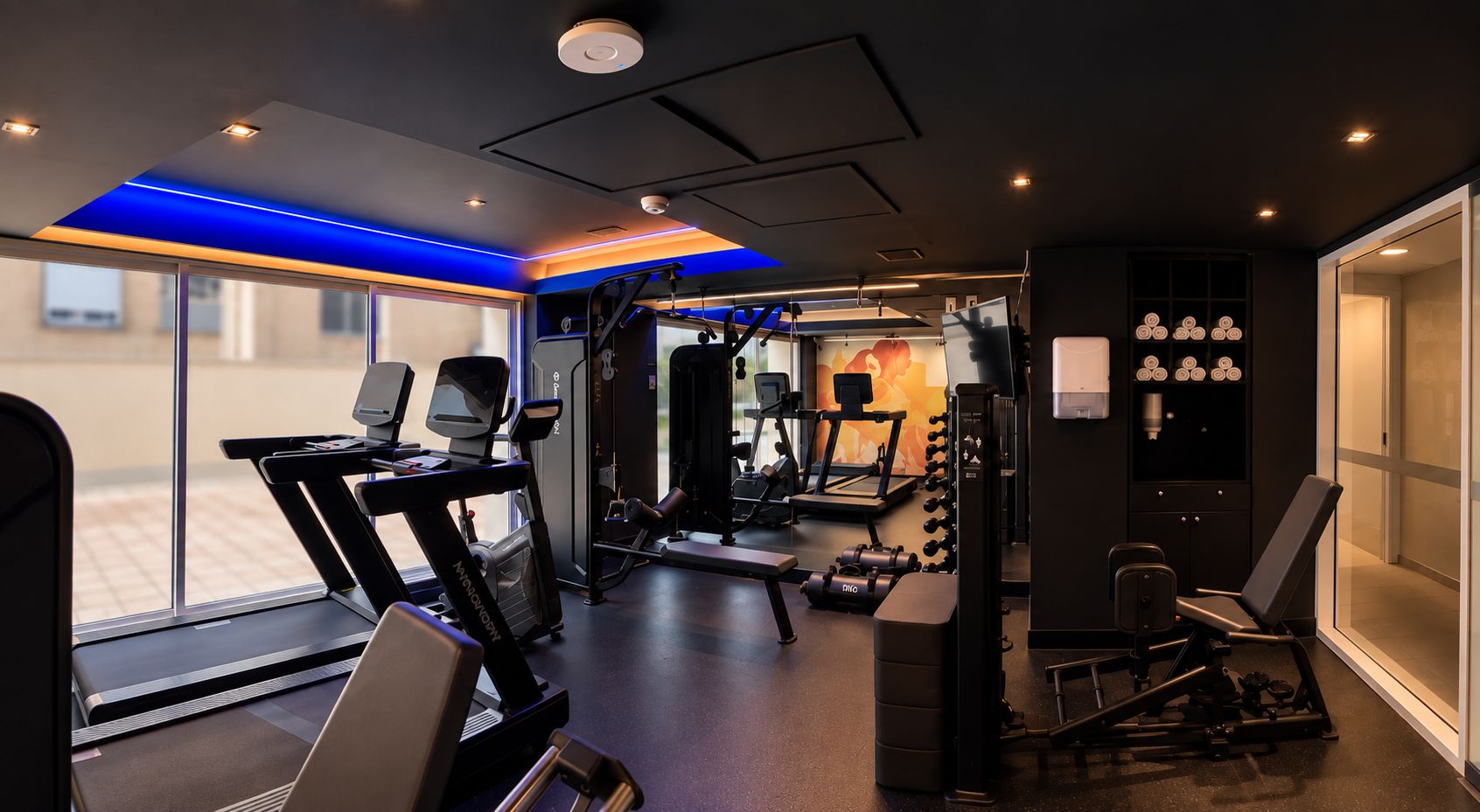 A gym with treadmills, weight machines, and a bench.