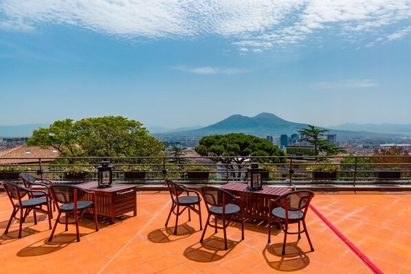 Enjoy panoramic views of the city and mountain from this rooftop space, perfect for dining or socializing.