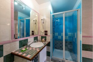 A bathroom with a sink, mirror, and shower. - Atlanta Augustus (Venice)