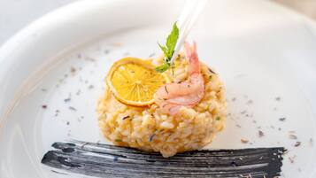 A plate of risotto with shrimp and a lemon slice garnish.