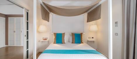 Un dormitorio moderno con cama a dosel, lámparas de noche y una paleta de colores neutros.