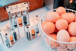 A kitchen counter with a timer set to 5 minutes and a basket of eggs.
