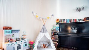 A play kitchen with a toy stove, a toy refrigerator, and a toy washing machine. There is a play tent in the center of the room. - Hotel Villa Aurora (Lezzeno)